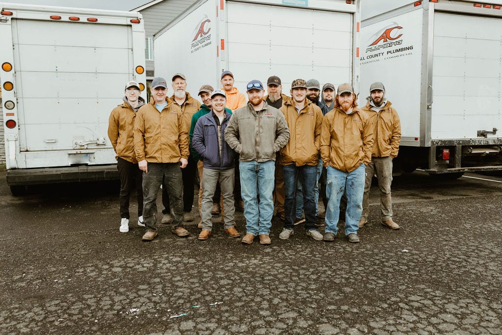 All County Plumbing crew standing in front of company service trucks in Vancouver, Washington