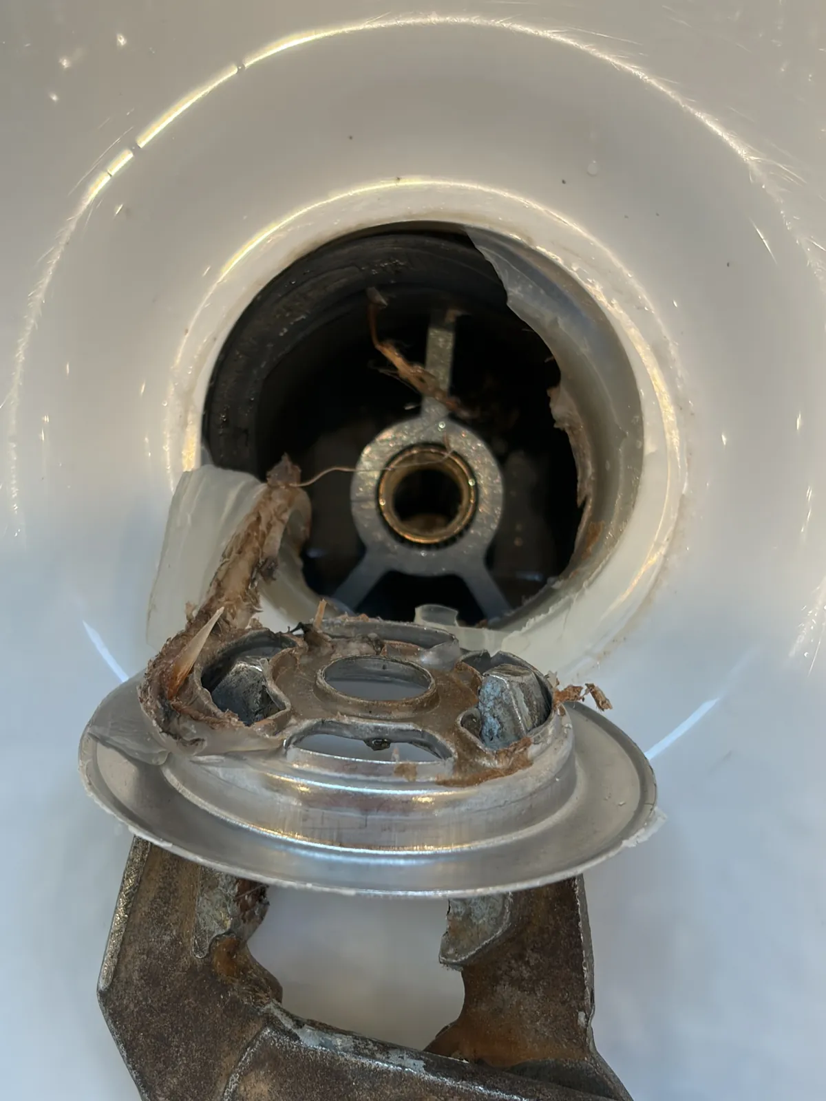 Close-up of a bathtub drain opening with the old drain flange removed