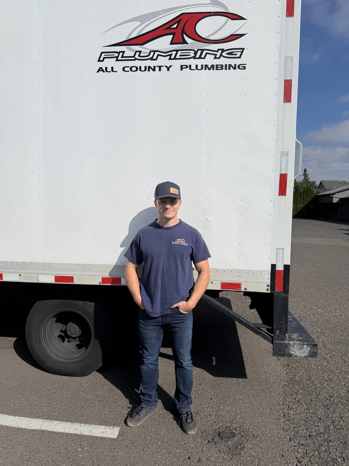 All County crew member standing beside a box truck with the company logo